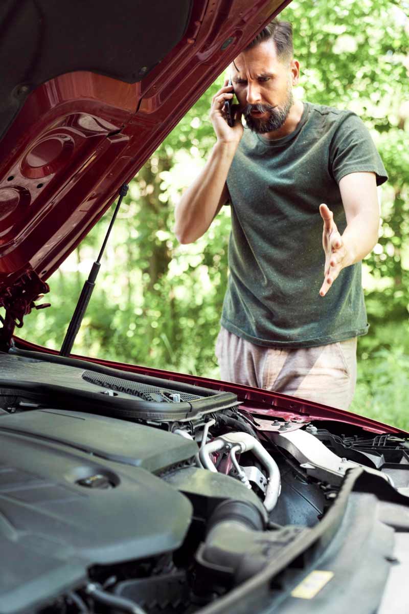 Junger Mann prüft Getriebeschaden bei Schrottauto Ankauf Einbeck